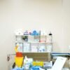 Neatly arranged medical supplies on a shelf in a hospital setting, featuring gloves, containers, and paperwork.