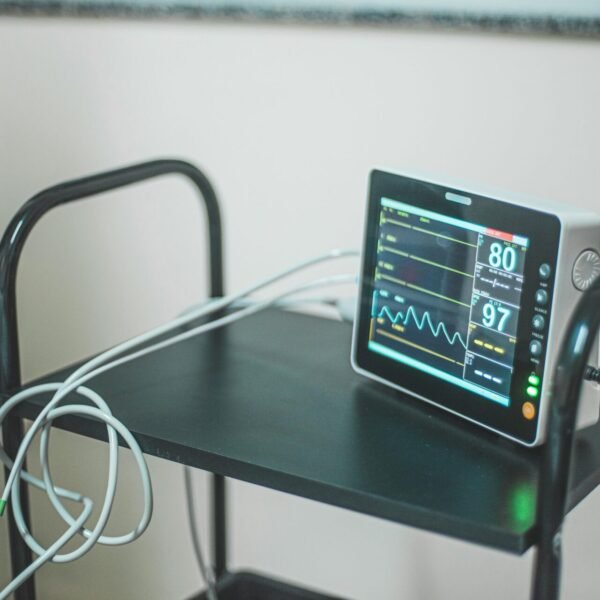 Medical equipment showing heart rate on screen in hospital room.